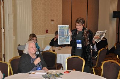 NNA Past President Diane Everson (left), publisher of The Edgerton (Wisconsin) Reporter, told how they partner with the Chamber of Commerce to produce a tourism special section. “It makes the difference between a good year and not so good year,” she said. Moderator Jody Hanson, publisher of The Echo Press in Alexandria, Minnesota, presents the sections to attendees.