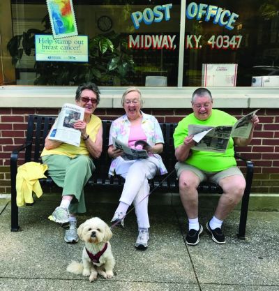 Margie Stedman, Shirley Davis and Lou Taylor enjoy a print edition of the Midway Messenger outside the post office, with Lou s dog Molly. (The Rural Blog)