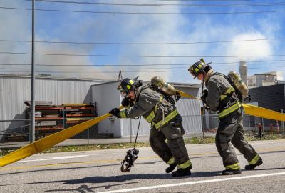 Firefighters lay down hoses along Highway 97A Friday afternoon, July 15, 2022, as smoke and fire come from Keyes Fibre’s manufacturing plant in the background. Chelan County Fire Department was hoping to contain the fire to two of seven areas inside the building. (Don Seabrook | The Wenatchee (Washington) World) Firefighters lay down hoses along Highway 97A Friday afternoon, July 15, 2022, as smoke and fire come from Keyes Fibre’s manufacturing plant in the background. Chelan County Fire Department was hoping to contain the fire to two of seven areas inside the building. (Don Seabrook | The Wenatchee (Washington) World)